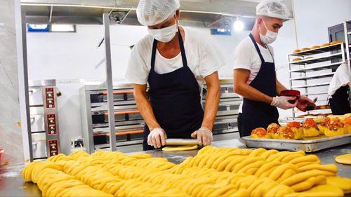 Dù có sự hỗ trợ của máy móc nhưng nhiều công đoạn làm bánh vẫn được thực hiện thủ công. Ảnh: Khánh Chi