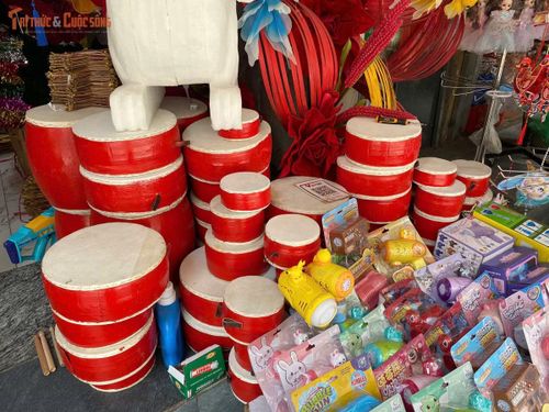 Trống quân bọc da truyền thống được xếp thành từng chồng cao ngất cạnh các món đồ chơi thổi bong bóng, súng đồ chơi hiện đại.