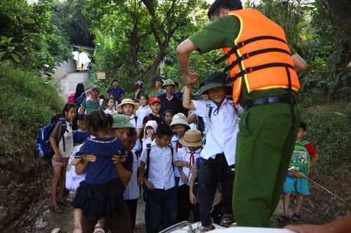 Người dân, học sinh lên cano của Phòng CSGT để qua sông đến lớp