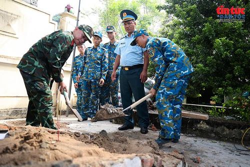 Cán bộ, chiến sĩ Trung đoàn 260 phối hợp với các lực lượng cẩn trọng bóc từng lớp đất trong quá trình khai quật phần mộ liệt sĩ.