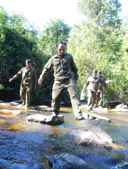 Các thành viên trong tổ vượt suối đi tuần tra rừng