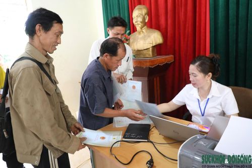 Cán bộ Trung tâm Phục vụ hành chính công xã Nhôn Mai hỗ trợ người dân thực hiện thủ tục hành chính ngay tại bản. Ảnh: Song Hoàng.