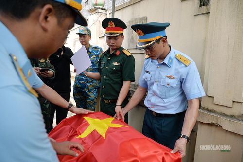 Tiểu hài cốt được bàn giao giữa các lực lượng trước khi chuyển tới khu vực pháp y. Ảnh: Tuấn Anh