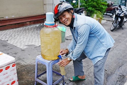 Tài xế Kính Phát lấy nước trước cửa tiệm vàng.