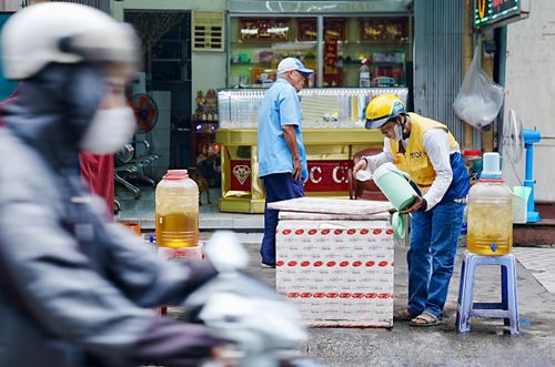 Thùng trà đá miễn phí được đặt trước tiệm vàng trên đường Lê Văn Lương, phục vụ người đi đường suốt khoảng 20 năm.