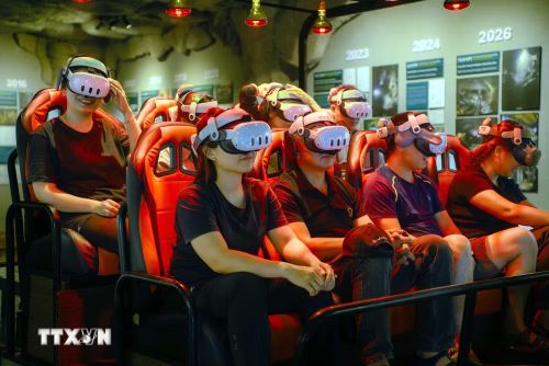 Khách tham quan trải nghiệm tour thám hiểm hang động Sơn Đoòng bằng công nghệ thực tế ảo (VR 5D). (Ảnh: Tá Chuyên/TTXVN)