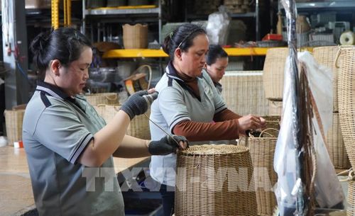 Công nhân sản xuất sản phẩm thủ công mỹ nghệ từ dây nhựa. Ảnh: Nhựt An - TTXVN