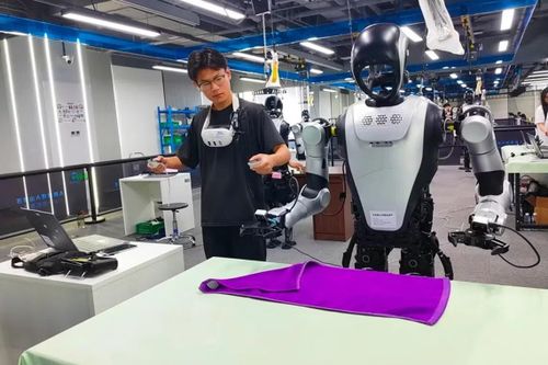 Các chuyên gia đào tạo dữ liệu tại Trung tâm Đào tạo Dữ liệu Robot Hình người Shijingshan ở Bắc Kinh hướng dẫn robot cách gấp khăn lau