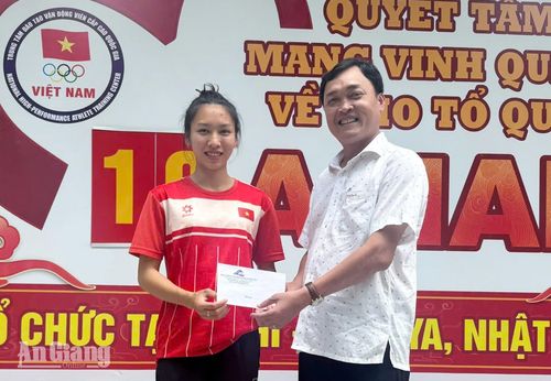 Giám đốc Trung tâm Đào tạo, huấn luyện và thi đấu thể dục thể thao tỉnh An Giang Đặng Anh Kiệt tặng quà cho vận động viên Lê Thị Cẩm Tú.