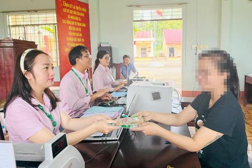 Nhân viên Ngân hàng Chính sách xã hội chi nhánh thành phố Đồng Nai giải ngân vốn chương trình tín dụng chính sách cho gia đình có con đi học ở ấp Thạnh Biên, xã Lộc Thạnh. Ảnh: C.T.V