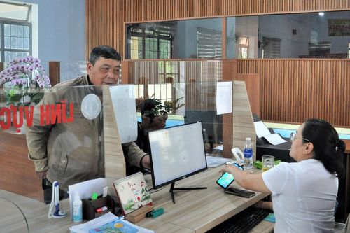 Cán bộ hướng dẫn người dân làm thủ tục hành chính qua điện thoại thông minh tại Trung tâm Phục vụ hành chính công xã Tân Hội