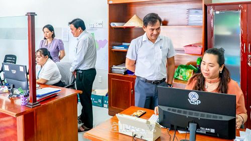 Ông Phạm Văn Phúc, Phó Giám đốc Viettel Cà Mau (thứ hai từ trái sang), hướng dẫn công chức phường An Xuyên sử dụng phần mềm KPI. Ảnh: NHẬT MINH