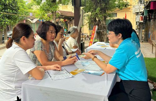 Cán bộ Bảo hiểm xã hội thành phố Hà Nội tư vấn chính sách bảo hiểm xã hội tự nguyện cho người dân. Ảnh: Bảo Duy