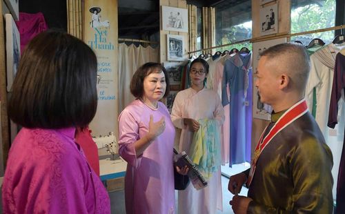 Nghệ nhân trò chuyện, giới thiệu với du khách về áo dài Trạch Xá. 