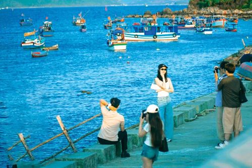 Các bạn trẻ check-in ở bờ kè xóm Chụt. Ảnh: HOÀI BÃO