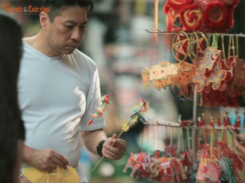 Một du khách nước ngoài thích thú với những chú tò he.