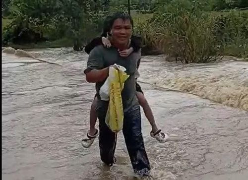Duy cõng trẻ em qua dòng suối.