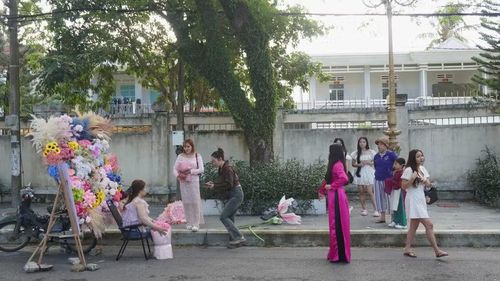  Người dân chờ đợi để chụp ảnh bên chiếc xe chở hoa mang tông màu của mùa thu. Ảnh: Chu Hằng 