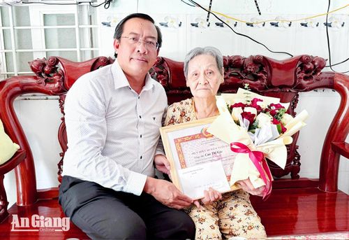 Phó Bí thư Thường trực Đảng ủy phường Hà Tiên Dương Văn Thuận trao Huy hiệu 65 năm tuổi Đảng cho bà Cao Thị Cúc tại nhà. Ảnh: DANH THÀNH