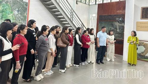 Thuyết minh viên giới thiệu các hiện vật tại Bảo tàng Hùng Vương cho du khách.