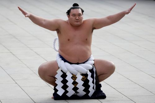 Hakuho Sho, cựu võ sĩ sumo hạng Yokozuna, đặt ngọn lửa lên đài trong lễ tiễn ngọn lửa ở Nagoya đêm 18/9, kết thúc hành trình rước đuốc. Ảnh: Reuters.