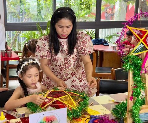  Chị Lê Thị Ái Vy hướng dẫn các bạn nhỏ thực hiện từng công đoạn làm lồng đèn. Ảnh: D.L 