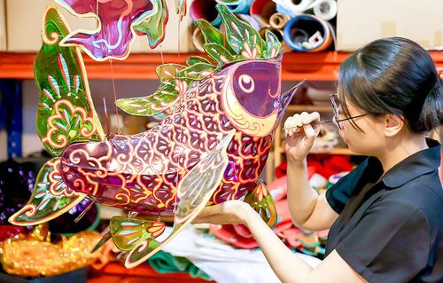 Nghệ nhân Nguyễn Thị Kim Thủy, trưởng nhóm Khởi đăng tác khí, trang trí lồng đèn cá chép. Ảnh: HOÀNG TRIỀU