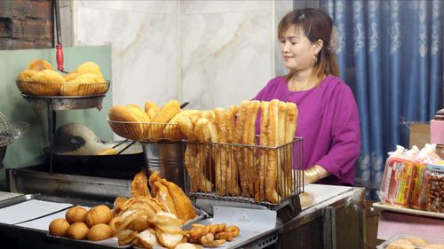 Chị Lý Ngọc Bình bên quầy bánh tiêu của mình. Ảnh: DIỄM MI