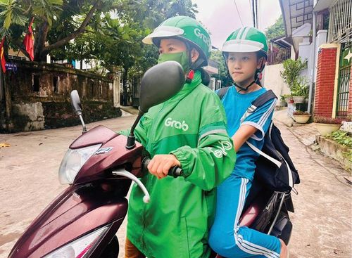 Tài xế xe công nghệ đưa học sinh về nhà sau giờ tan học.