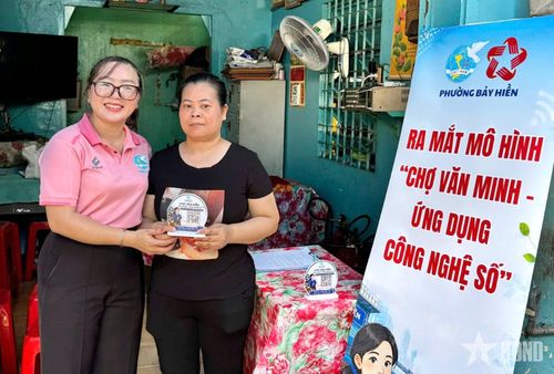 Cán bộ phụ nữ phường Bảy Hiền trao bảng mã QR “Chợ văn minh-Ứng dụng công nghệ số” cho tiểu thương.