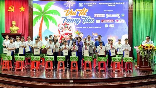 Đồng chí Đặng Thị Ngọc Thịnh, nguyên Ủy viên Trung ương Đảng, nguyên Phó Chủ tịch nước cùng nhà tài trợ trao quà cho các em thiếu nhi. (Ảnh: BÁ DŨNG)