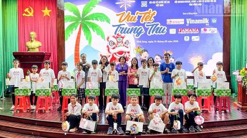 Đồng chí Đặng Thị Ngọc Thịnh, nguyên Ủy viên Trung ương Đảng, nguyên Phó Chủ tịch nước cùng nhà tài trợ trao quà cho các em thiếu nhi. (Ảnh: BÁ DŨNG)