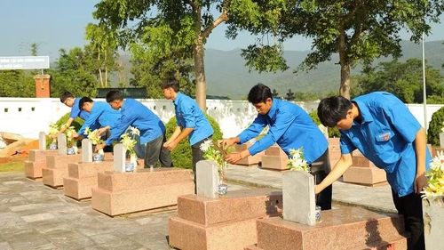 Học sinh Trường trung học phổ thông Thanh Nưa dâng hương trên phần mộ liệt sĩ tại Nghĩa trang Liệt sĩ Tông Khao. (Ảnh: LÊ LAN)