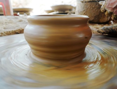 Một chiếc bình dần thành hình trên bàn xoay chuốt gốm