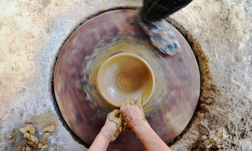 Bàn xoay chuốt gốm cần hai người thợ, một người đạp bàn xoay, người còn lại tạo hình sản phẩm