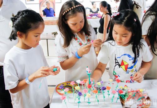 Các em nhỏ thích thú tập nặn tò he dưới sự hướng dẫn của nghệ nhân và tình nguyện viên.