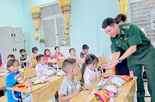 Cán bộ Đồn Biên phòng Thàng Tín chia quà cho học sinh Trường PTDT bán trú Tiểu học & THCS Thàng Tín.
