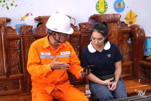Nhân viên Điện lực hướng dẫn khách hàng tra cứu điện tiêu thụ hằng ngày trên app EVN CSKH.