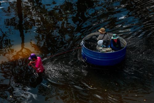 Một người đàn ông kéo phao tự chế qua Cơ quan Thể thao Thái Lan sau khi nước ngập quá eo. Tính đến sáng 29/9, bên trong Sân vận động Quốc gia Rajamangala vẫn ngập gần 1 m; hơn 100 ôtô và xe máy bị bỏ lại trong nước, nhiều chiếc ngập gần tới nóc.