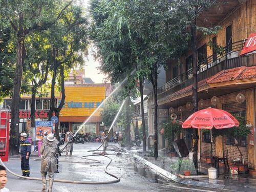 Lực lượng chức năng đang khẩn trương xử lý đám cháy, ngăn chặn ngọn lửa lây lan. Ảnh: Lê Đông - TTXVN 