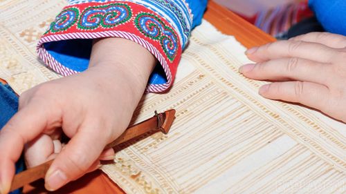 Để vẽ sáp ong trên vải, đôi tay người phụ nữ Mông Hoa phải rất tỉ mỉ và chính xác, thể hiện kỹ thuật thủ công lâu đời.
