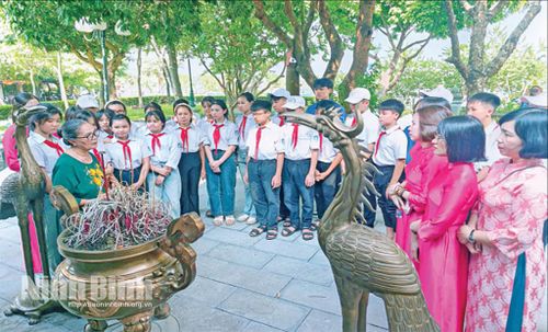 Bà Vũ Hồng Nhu (đứng ngoài cùng bên trái) chia sẻ với thế hệ trẻ về sự hy sinh anh dũng của cácAnh hùng liệt sĩ Trung đội pháo phòng không Lam Hạ. Ảnh: CTV
