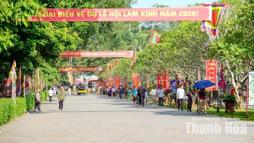 Tuyến đường dẫn vào Khu di tích rợp bóng cây xanh với hệ thống cờ hội, băng rôn và khẩu hiệu chào mừng đại biểu về dự Lễ hội Lam Kinh năm 2026.
