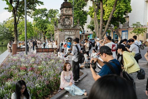  Ghi nhận lúc 15h, khu vực quanh các thảm hoa ven Hồ Gươm đông người đến chụp ảnh. Nhiều nhóm bạn mang theo máy ảnh, điện thoại cùng các thiết bị hỗ trợ như đèn flash, tấm hắt sáng để tự thực hiện bộ ảnh.