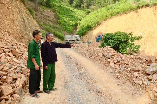 Ông Vi Văn Nhớn cùng người dân thôn Cao Minh trao đổi về đoạn đường đang được thi công