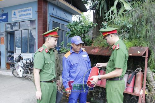 Công an xã Phù Yên hướng dẫn nhân viên cây xăng cách sử dụng bình chữa cháy.