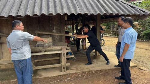 Du khách hào hứng trải nghiệm xay gạo bằng cối đá truyền thống của đồng bào dân tộc Mông ở Tù Lu-Tìa Ló. (Ảnh: LÊ LAN)