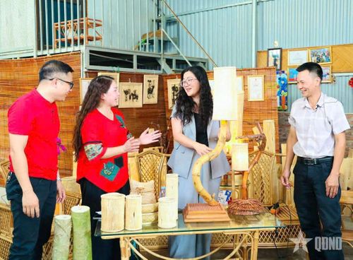 Khách tham quan tìm hiểu sản phẩm đèn làm từ thân cây đu đủ tại cơ sở sản xuất ở làng Phú Vinh, xã Phú Nghĩa (Hà Nội).