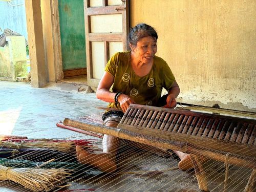 Người dệt thực hiện úp, ngửa khố trên khung dệt