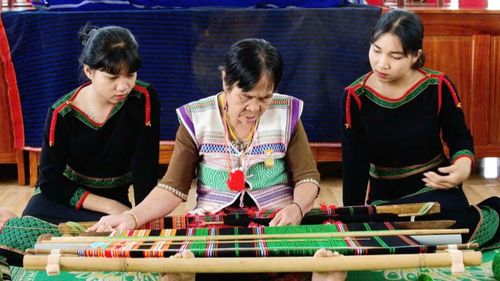 Bà Bờ Đam Thị Hạch (ngồi giữa) hướng dẫn cho con cháu. (Ảnh: HẰNG)